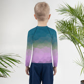 Child wearing Jack's Magic Beanstalk Rash Guard climbing outdoors.